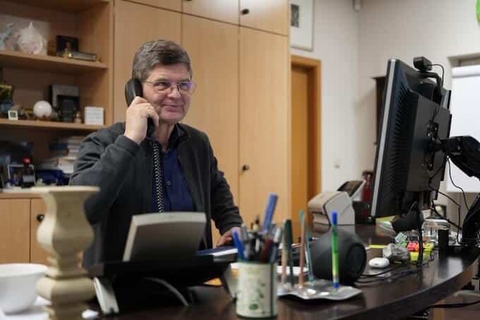 Mitarbeiter telefoniert im Berliner Büro einer Firma für Arbeitsplatten aus Naturstein, Schreibtisch mit Computer und Unterlagen.